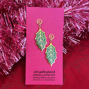 Rather Keen Holly Earrings for Christmas displayed on their pink backing card amongst pink garland 