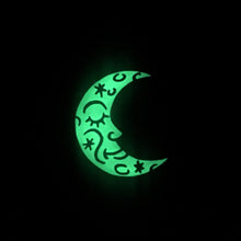 A glowing moon-shape lapel pin