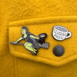 Witch enamel pin and Witch’s Brew pin on jacket pocket