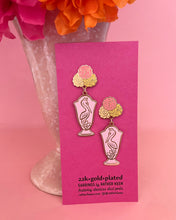 Antique style flower vase earrings on display card.