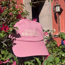 vamos a la biblioteca hat posed outside a library