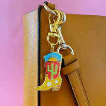 Desert theme cowgirl boot charm shown clipped to a bag