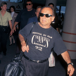 Actor Joe Pesci walking through an airport in 1998 wearing a 1992 Cannes shirt