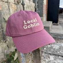 Raspberry pink color dad hat with Local Goblin embroidered on it