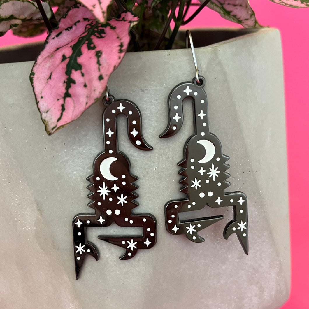 Black metal scorpion earrings with white enamel stars