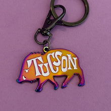 Rainbow-black metal keychain in javelina shape with the word Tucson on its side