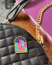 Bookish Vamos a la Biblioteca pin styled on purse.