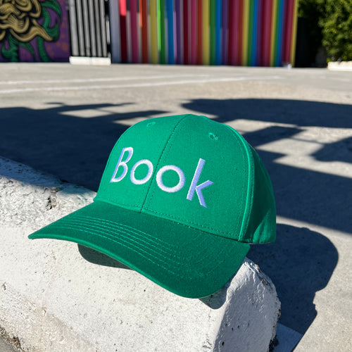 Book hat by Rather Keen. The Green baseball hat features the word “Book”