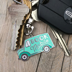 The Bookmobile keychain by Rather Keen. This metal keychain is shaped like a 1940s truck with the words Book Mobile on its side.