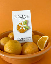 Geometric orange and flower pin on display card