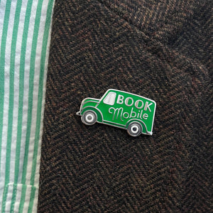 Green bookmobile lapel pin by Rather Keen depicted on a sport coat lapel.