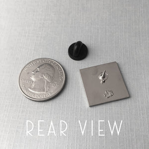 comparison of the Book Shop pin size to an American quarter coin