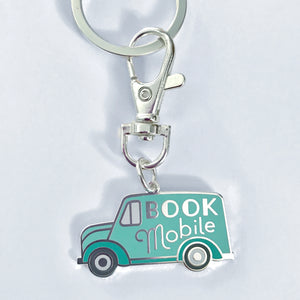 The Bookmobile keychain is shaped like a 1940s truck with the words Book Mobile on its side 