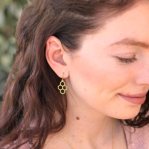 Model wearing gold honeycomb earrings